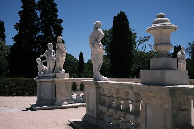 A group of statues sitting on top of a cement wall